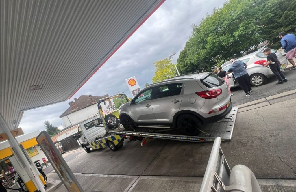 RJ Recovery London towing a family SUV-style vehicle near a petrol station in London
