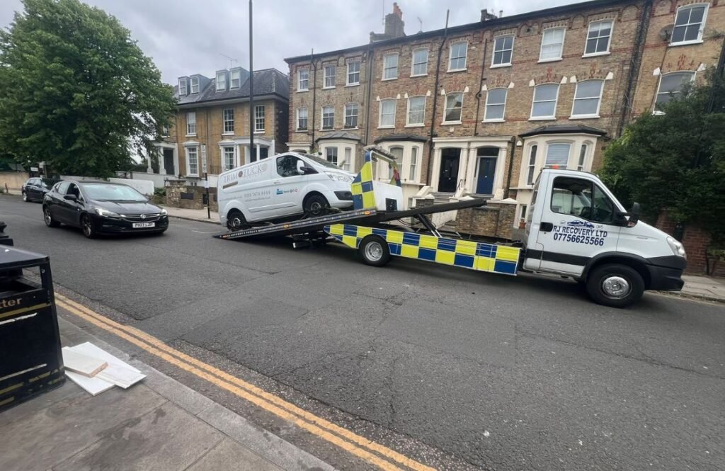 Truck towing van in London