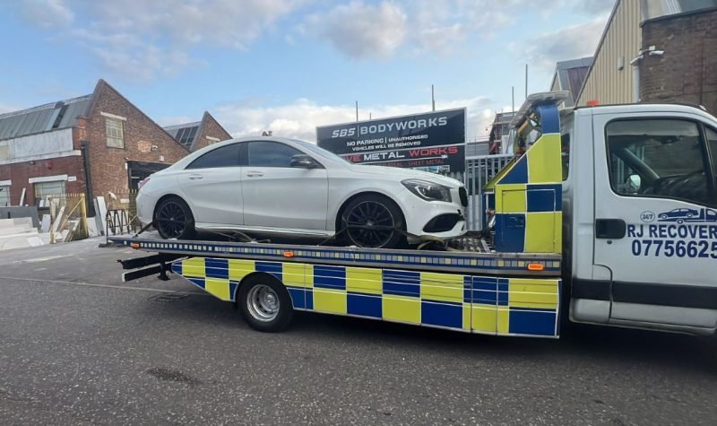 RJ Recovery London transporting a white car to a vehicle body repair workshop in London